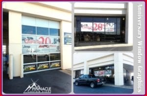 Exterior window graphics at a business location, showcasing anniversary-themed designs. The large windows display promotional graphics celebrating a 20th anniversary, with prominent red '20' and other text detailing the celebration. The images are featured on various windows around the building, creating a cohesive look.